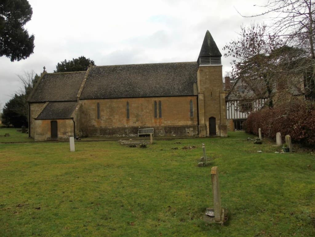 St Nicholas' Church, Burmington, with its stone tower and churchyard