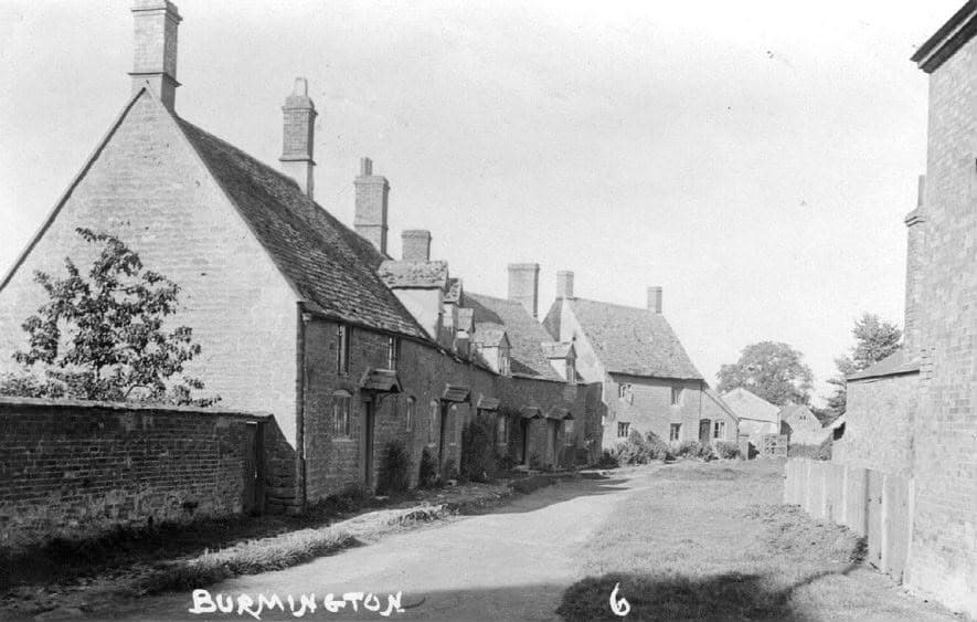 Historical black and white photograph of a stone cottage-lined street in Burmington
